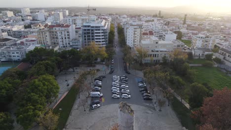 Drone-Volando-Hacia-Atrás-Revelando-El-Monumento-Del-Ingeniero-Duarte-Pacheco-Con-El-Paisaje-Urbano-De-Loulé-Al-Fondo