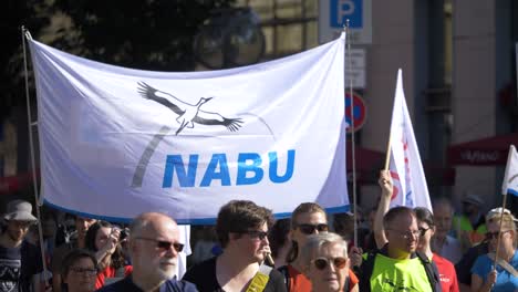 Fridays-For-Future-FFF-Protest-Mit-Jungen-Und-älteren-Aktivisten,-Die-Gemeinsam-Marschieren-Und-Ein-Nabu-Zeichen-Gegen-Den-Klimawandel-Und-Für-Grüne-Energie-Und-Nachhaltigkeit-In-Stuttgart,-Deutschland,-Halten