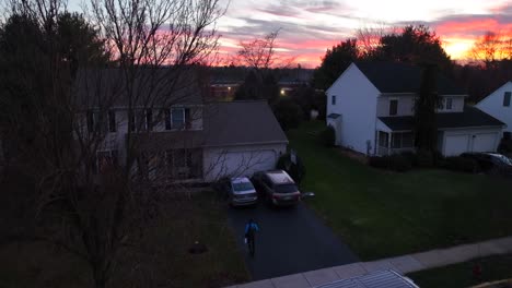 Repartidor-Masculino-Saliendo-De-La-Camioneta-Amazon-Prime-Y-Caminando-Hacia-Una-Casa-Americana-En-El-Vecindario-Con-Un-Paquete-Al-Atardecer