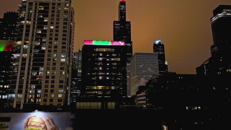 Vista-Aérea-Que-Se-Eleva-Frente-A-La-Torre-Willis-Desde-La-Puerta-Oeste,-Noche-Nublada-En-Chicago