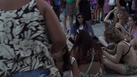 young-women-gather-around-and-sit-on-the-floor-during-rally-in-women's-day