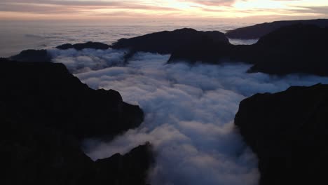 Drohne-Fliegt-Bei-Sonnenuntergang-über-Den-Wolken-Am-Pico-Do-Arieiro,-Madeira-Durch-Berge