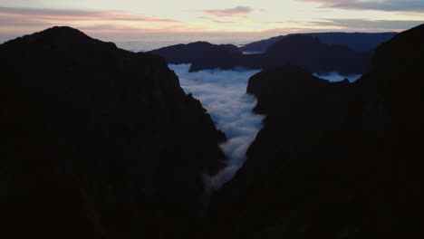 Drone-flying-through-rugged-mountains-in-the-sunset-at-Pico-Do-Arieiro,-Madeira