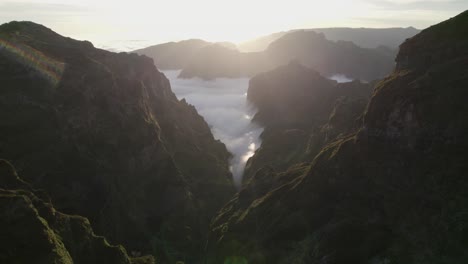 Drone-flying-through-rugged-mountains-in-the-sunset-at-Pico-Do-Arieiro,-Madeira