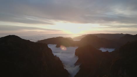 Drohne-Fliegt-Bei-Sonnenuntergang-über-Den-Wolken-Am-Pico-Do-Arieiro,-Madeira-Durch-Berge