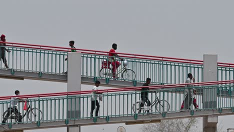 July-23,-2023,-labourers-can-be-seen-crossing-a-footbridge-that-connects-the-internal-area-to-the-residential-zone-along-E311-in-Dubai,-United-Arab-Emirates