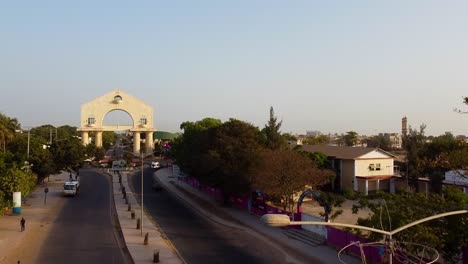 Recorrido-Aéreo-Por-La-Avenida-Hacia-El-Portal-Del-Arco-22-En-Banjul,-Gambia