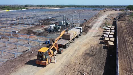 Aerial-drone-view-Many-men-are-unloading-and-taking-out-large-boxes-of-solar-panels