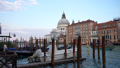 Muelle-Con-Barco-Y-Góndolas-En-El-Gran-Canal-De-Venecia-Con-Vistas-A-La-Basílica-De-Santa-María-Della-Salute.