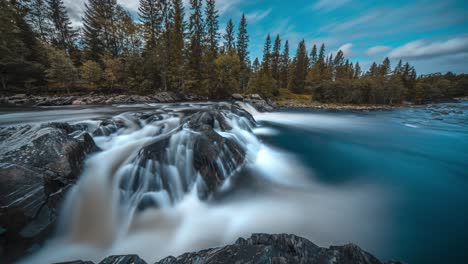 Una-Pequeña-Cascada-En-El-Río-De-Montaña-Poco-Profundo-Cae-En-Cascada-A-Través-Del-Lecho-Rocoso-Del-Río