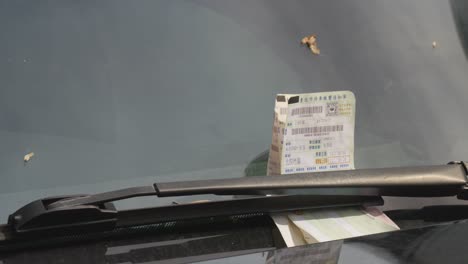 Close-Up-of-Parking-Tickets-on-Car-Windshield-in-Taipei,-Taiwan