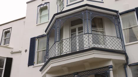 Low-angle-shot-of-beautiful-balcony-along-Twickenham-architecture-in-London-suburbs,-UK-during-evening-time