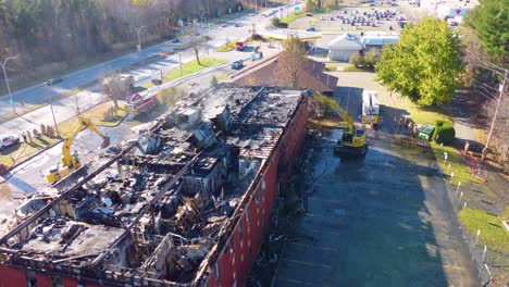 Aerial-View-Of-Roof-Fire-Collapse-Of-Warehouse-With-Excavators-Demolishing-In-Blainville,-Quebec