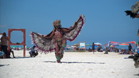 Cámara-Lenta-De-Una-Bailarina-Disfrazada-De-Guerrera-águila-Maya-Actuando-Y-Saltando-En-La-Arena-De-Una-Playa-En-México