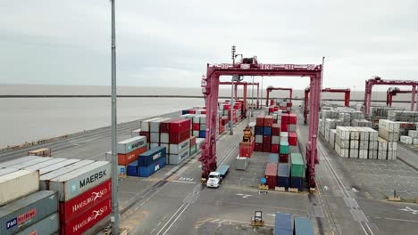 Luftaufnahme-Von-Frachtcontainern-In-Einem-Geschäftigen-Hafen-Mit-Lastkraftwagen-Und-Kränen,-Bewölkter-Tag-Im-Hafen-Von-Buenos-Aires