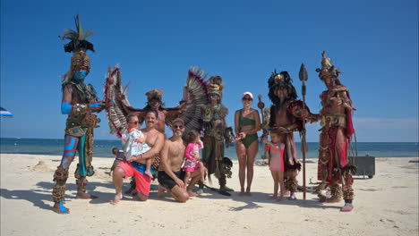 Toma-En-Cámara-Lenta-De-Una-Familia-Posando-Con-Una-Compañía-De-Bailarines-Actuando-Como-Guerreros-Mayas