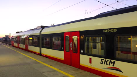 Sonnenaufgang-Am-Frühen-Morgen-Und-Ein-Polnischer-SKM-Zug-Am-Warschauer-Ostbahnhof-In-Polen,-Bahnhof-Warszawa-Wschodnia,-4K-Aufnahme