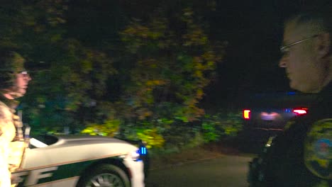 Police-And-Armed-Response-Unit-Guiding-Armoured-Police-Truck-Slowly-Driving-At-Night-In-Lewiston,-Maine