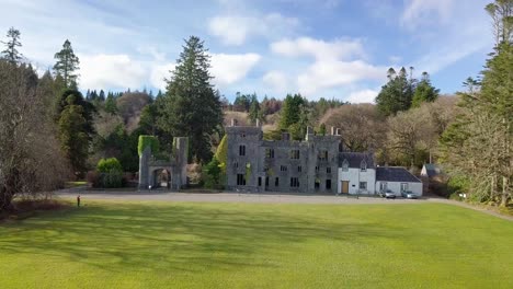 Vista-Aérea-Inclinada-Hacia-Arriba-Del-Antiguo-Castillo-De-Armadale-En-El-Paisaje-Forestal-De-Escocia-Durante-El-Día-Soleado