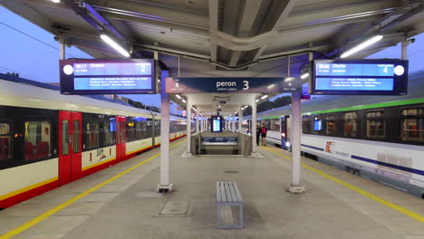 People-walking-near-two-trains-at-the-Warsaw-East-Station-in-Poland,-Warszawa-Wschodnia-train-station,-4K-static-shot