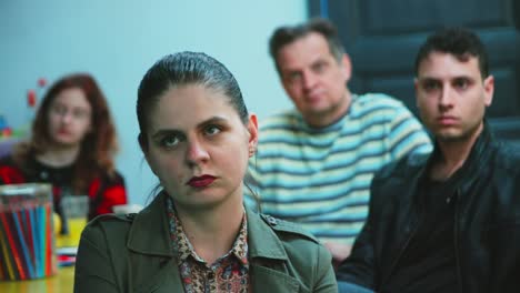 Two-woman-and-man-of-different-age-listening-to-presentation-inside-an-office