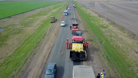 Road-construction-with-workers-and-machinery,-daytime-in-Buenos-Aires,-aerial-view