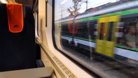 Empty-InterCity-train-seat-inside-an-IC-train-in-Poland,-fast-moving-train-passing-by,-public-transport,-4K-shot