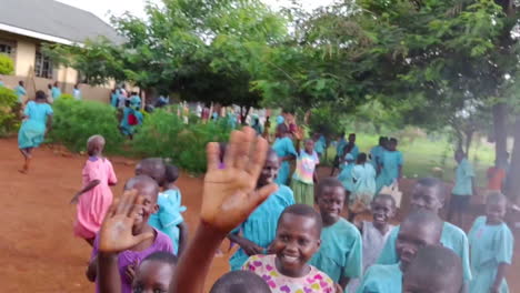 А-young-traveler-takes-a-selfie-with-a-group-of-children-in-a-schoolyard-in-Uganda