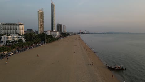 Peaceful-wide-sandy-beach-at-sunset-with-calm-seas