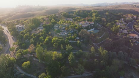 Flug-über-Die-Ruhige-Gegend-Der-Versteckten-Hügel-Calabasas-In-Los-Angeles,-Kalifornien,-Zur-Goldenen-Stunde-Mit-Bergen-Am-Horizont