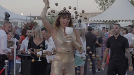 Toma-En-Cámara-Lenta-De-Una-Bailarina-Con-Un-Traje-Dorado-Abstracto-Parada-En-Una-Plataforma