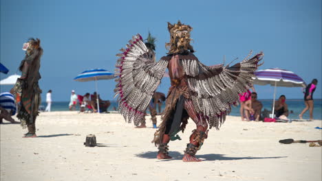 Cámara-Lenta-De-Un-Hombre-Latino-Vestido-Como-Un-Guerrero-águila-Maya-Bailando-Y-Actuando-En-Una-Playa-En-México