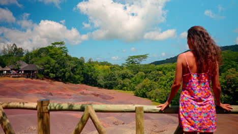 Back-shot-of-young-girl-with-colorful-dress-enjoying-the-view-of-the-Seven-Colored-Earths-in-Chamarel-in-the-Mauritius-island