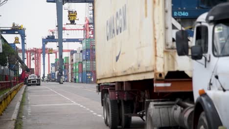 Alter-LKW,-Der-Durch-Ein-Belebtes-Handelshafengebiet-Fährt,-Das-Von-Bunten-Schiffscontainern-Gesäumt-Ist,-Im-Hafen-Von-Buenos-Aires