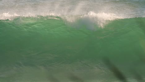 Surfer-paddling-over-a-wave-on-a-sunny-day,-Burleigh-Heads,-Gold-Coast,-Australia