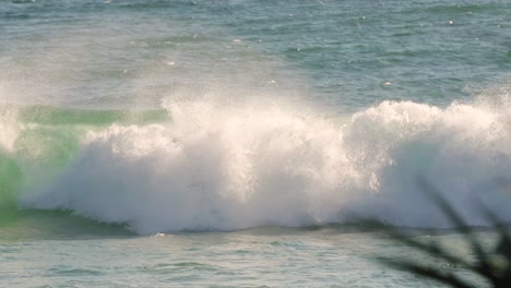 Surfer-diving-under-a-wave-while-paddling-out-on-a-sunny-day,-Burleigh-Heads,-Gold-Coast,-Australia