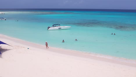 Unberührte-Strände-Und-Türkisfarbenes-Wasser-Von-Los-Roques,-Venezuela-Mit-Booten-Und-Sonnenschirmen,-Luftaufnahme