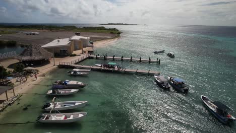 Los-Roques-archipelago-in-Venezuela-with-clear-waters,-boats,-and-coastal-buildings,-aerial-view