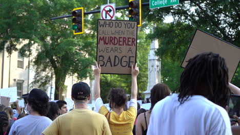 Young-protestor-holding-police-brutality,-violence,-and-black-lives-matter-sign-at-city-rally