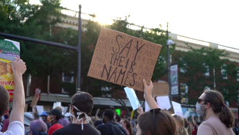 Una-Joven-Sostiene-Un-Cartel-De-Brutalidad-Policial-De-Black-Lives-Matter-En-Una-Protesta-Pacífica-En-Las-Calles-De-La-Ciudad.