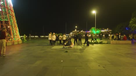 Hombres-Jóvenes-Bailando-Breakdance-Junto-Al-árbol-De-Navidad-Por-La-Noche-En-Funchal,-Madeira,-Portugal