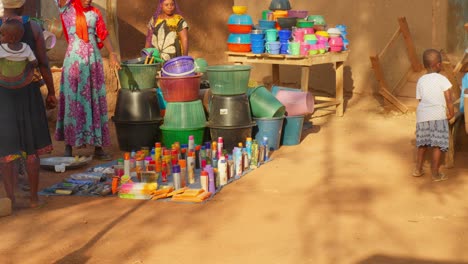 local-market-stand-in-africa-remote-village-with-woman-in-traditional-clothing-and-black-child-playing-under-the-sun