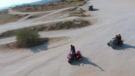 Cappadocia-ATV-Tour---Adventurous-Man-Waves-To-Drone-Camera-While-Standing-On-Quad-Bike-In-Turkey