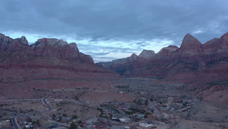 Amplia-Toma-Aérea-De-La-Ciudad-De-Springdale-Y-Coloridas-Montañas-Cerca-Del-Parque-Nacional-Zion,-Utah,-Estados-Unidos,-Filmada-Durante-La-Hora-Azul-De-La-Tarde