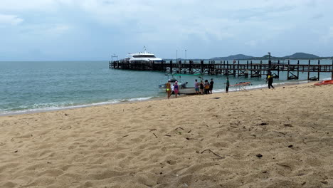 A-group-of-tourists-and-locals-carry-an-old-man-on-a-stretcher-from-an-ambulance-into-a-boat