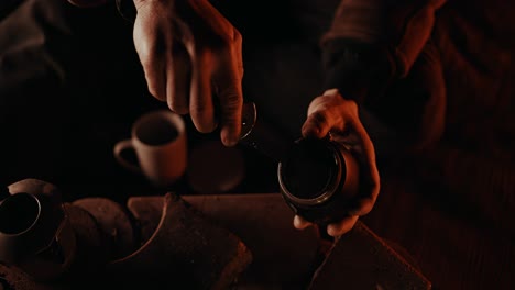 Campfire-Coffee:-Man-extracting-clumped-up-coffee-grounds-from-the-filter-of-his-moka-pot-using-his-trusty-old-knife