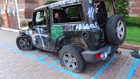 Beschossenes-Schwarzes-Jeep-Auto-Auf-Der-Chreschtschatyk-Hauptstraße-Aus-Dem-Russland-Ukraine-Krieg-Im-Stadtzentrum-Von-Kiew,-Zerstörtes-Kaputtes-Kriegsfahrzeug-In-Der-Ukraine,-Beschädigtes-Auto,-4K-Aufnahme