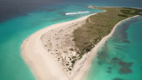 Serena-Playa-En-Los-Roques,-Venezuela-Con-Aguas-Cristalinas-De-Color-Turquesa-Y-Una-Sola-Sombrilla-Azul,-Vista-Aérea,-Timelapse