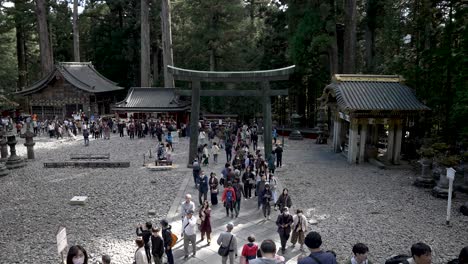 Turistas-Frente-A-La-Puerta-Torii-Central-En-Nikko-Toshogu,-Un-Venerado-Patrimonio-Cultural-En-Japón