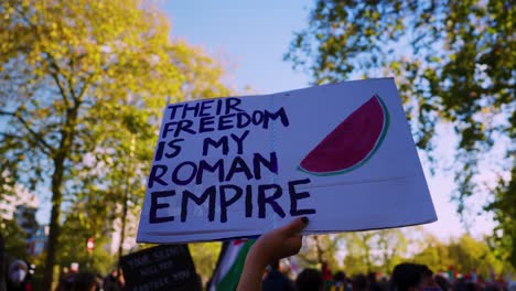 Demonstrator-holds-up-political-placard-message-at-National-march-for-peace-in-Palestine